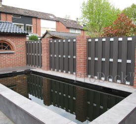 Gemetselde pilaren met luxe schuttingen, een mooie combinatie met de vijver die ervoor ligt. Luxe schutting • antraciet • aluminium dwarsbalken