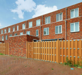 Nieuwbouwwoningen worden steeds vaker voorzien van composieten tuinafscheidingen. In dit geval zijn luxe bruine schuttingen met aluminium dwarsbalken geplaatst. Luxe schutting • bruin • aluminium
