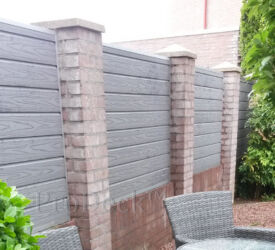 Een mooie, bijzondere schutting: composieten stapelplanken in grijs met houtnerf tussen gemetselde beertjes. composiet stapelplank grijs houtnerf