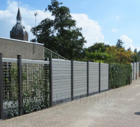 Hier een creatieve schutting, gemaakt van kruismatten waar de planten makkelijk tegenop groeien, in combinatie met grijze stapelplanken met houtnerfmotief. Stapelplankenschutting • grijs houtnerf
