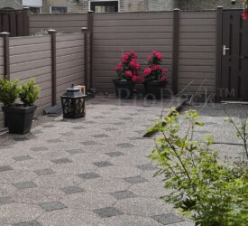 Houtnerfstapelplanken geven een natuurgetrouw beeld. In dit geval gecombineerd met antracieten palen en antracieten composieten deur. Stapelplankenschutting • vergrijsd bruin en antraciet