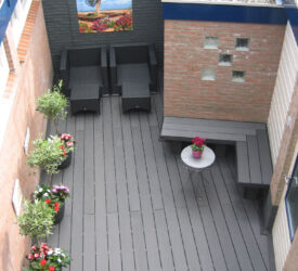 Een volledig ingebouwde stadstuin van donkerantracieten vlonderplanken met breedribbel profiel. Een plek om even de stad te ontvluchten ... Composiet • vlonderplank • donkerantraciet • breedribbel • stadstuin