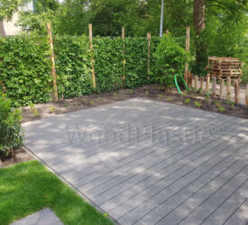 Een mooi terras met een verdekte naad in de kleur eben van Terafest® steekt goed af tegen het groen van het gras en de klimplanten. Vlonderplank • Terafest® • composiet • Rustic Top • eben • verdekte naad